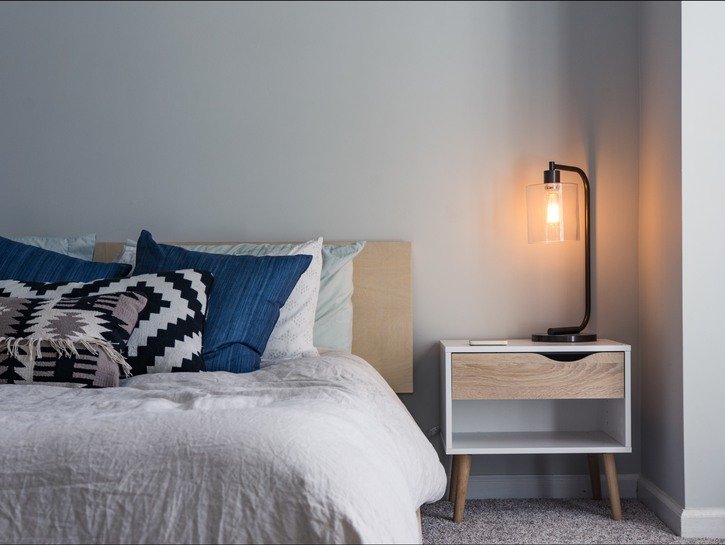 a bed next to a small end table