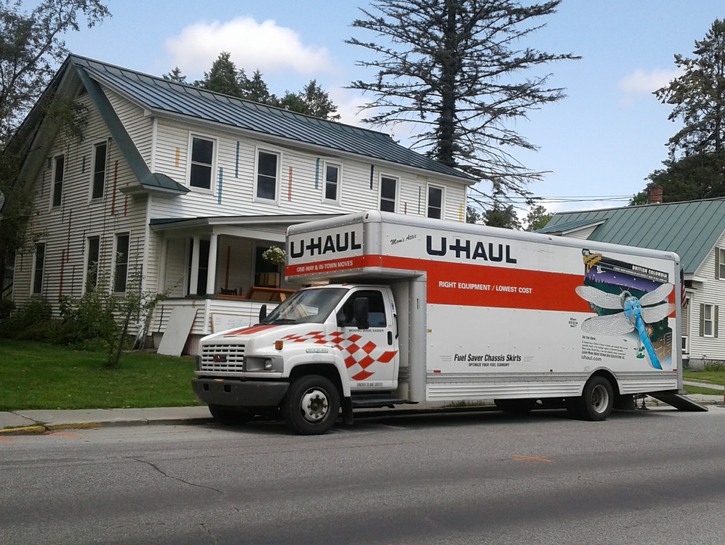 A UHaul truck in front of a house.
