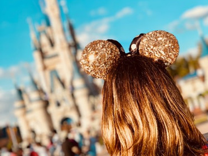 a woman standing in front of cinderella's castle