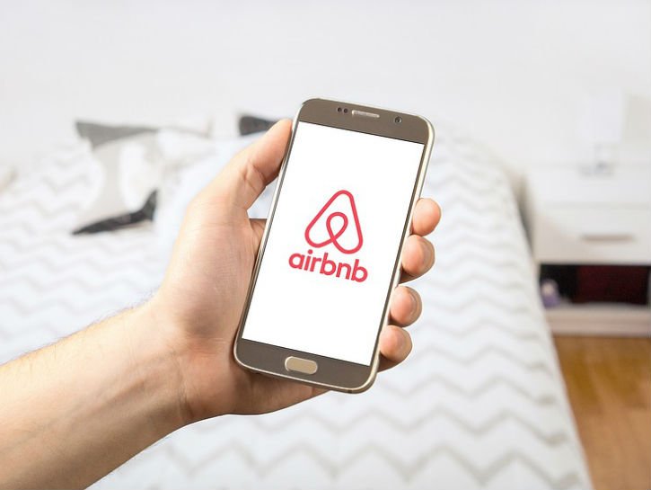 air bnb logo over a bed in a house