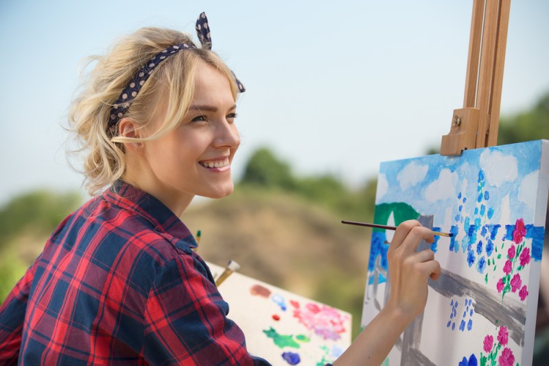 Art as therapy, art therapy. Beautiful blonde woman artist paints a colorful picture.