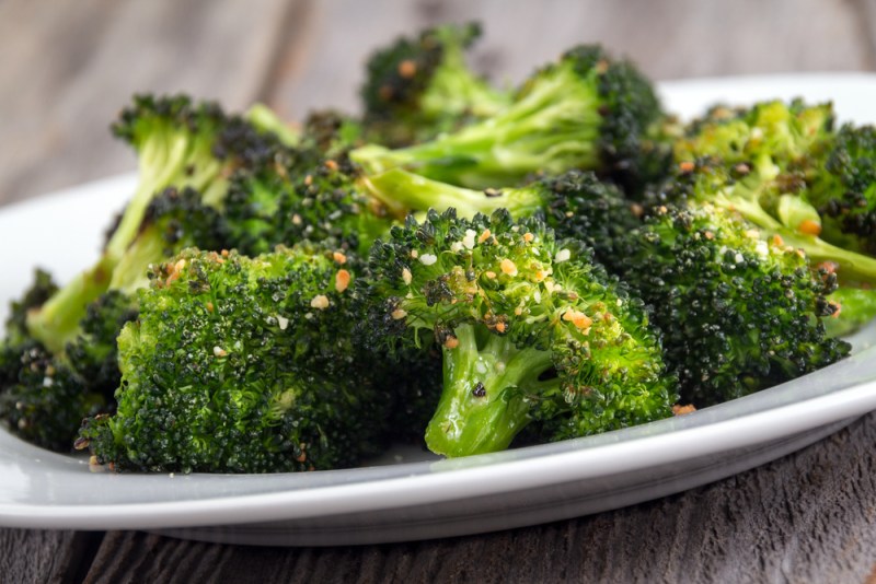 baked roasted garlic parmesan and olive oil broccoli side dish on wooden table