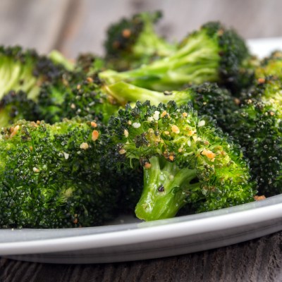 baked roasted garlic parmesan and olive oil broccoli side dish on wooden table