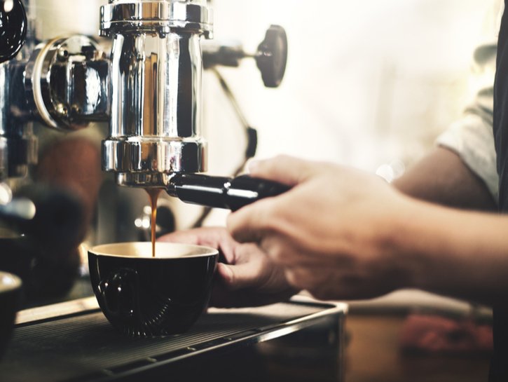 barista making coffee into a dark mug