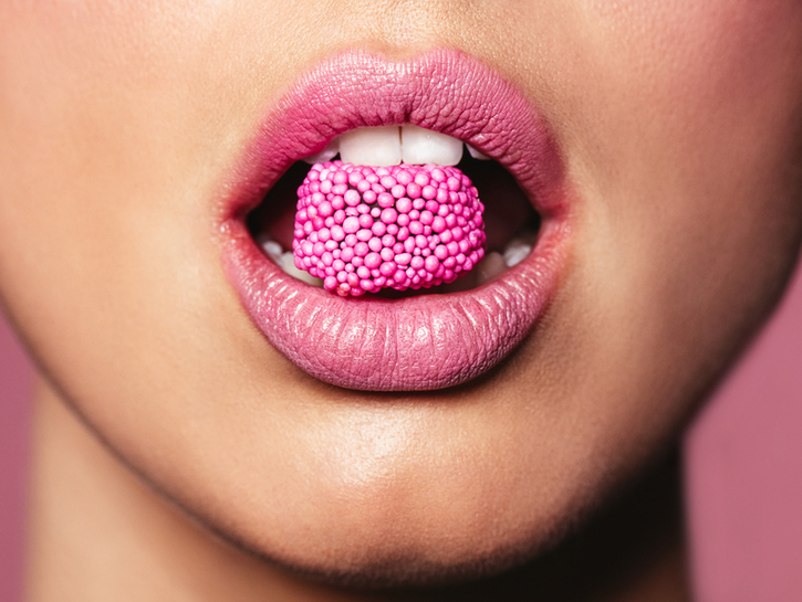 Beautiful pink lips with a piece of sweet candy
