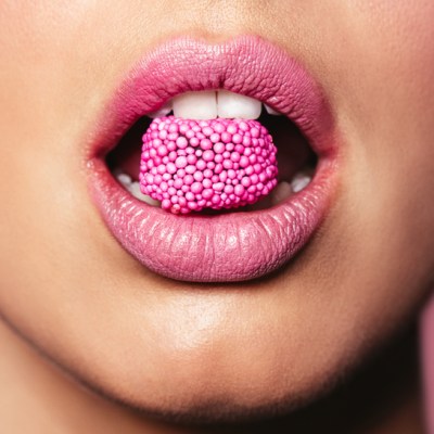 Beautiful pink lips with a piece of sweet candy