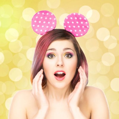 Beautiful young smiling woman in mickey mouse ears on bubble background.