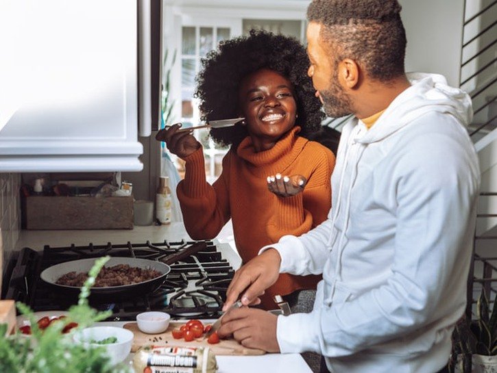 Black couple cooking together in the kitchen