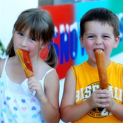 boy and girl eating corn dogs