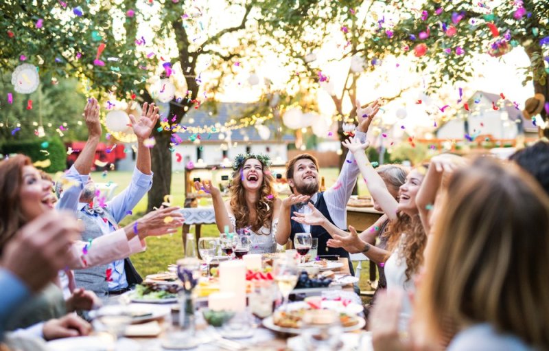 Bride and groom with guests at wedding reception outside in the backyard. How to rock your microwedding