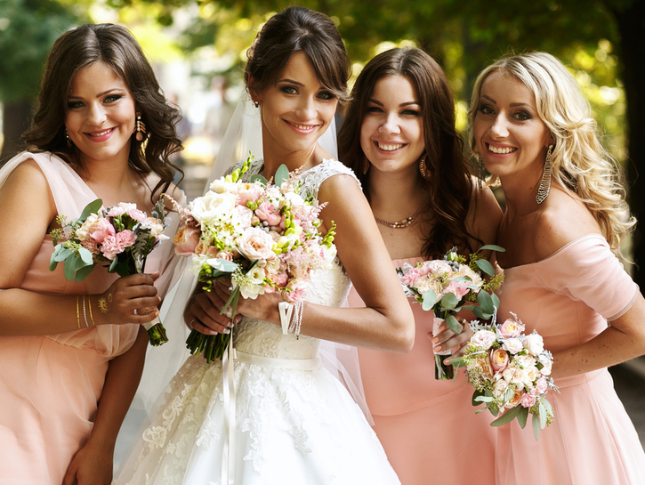 Bride with bridesmaids on the park on the wedding day