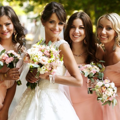 Bride with bridesmaids on the park on the wedding day