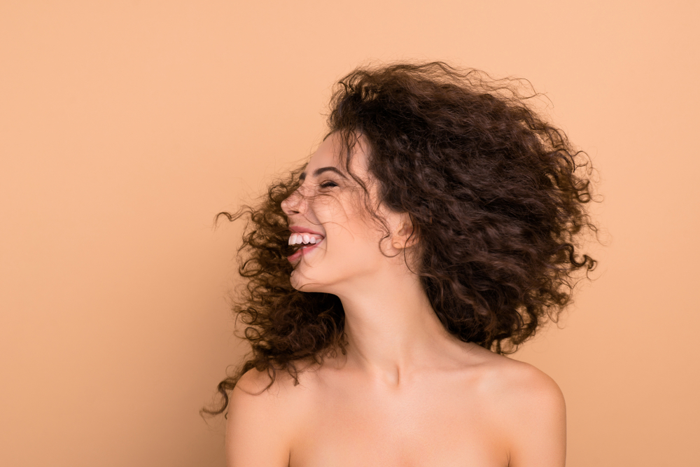 Close up photo beautiful she her lady laughter turn head side show great result after using shampoo hair cure long wave hairdo flight funky pretty positive wear no clothes isolated beige background