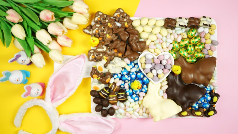 Colorful Happy Easter chocolate and candy eggs and bunnies dessert grazing platter charcuterie board.