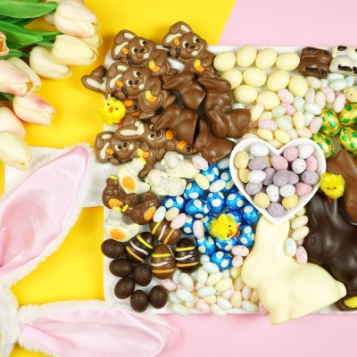 Colorful Happy Easter chocolate and candy eggs and bunnies dessert grazing platter charcuterie board.