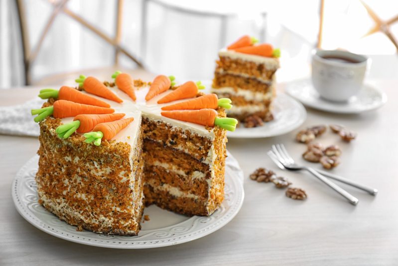 Delicious sliced carrot cake and tea on table