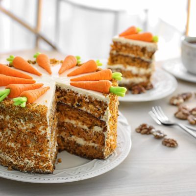 Delicious sliced carrot cake and tea on table