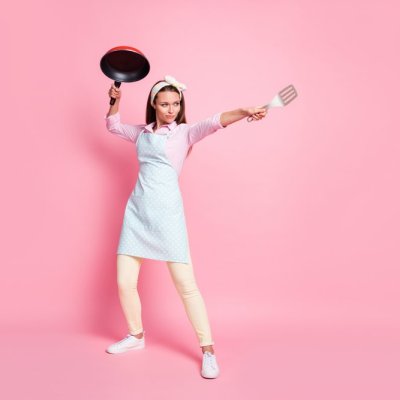 Full-size photo of strong chef woman hold frying pan spatula attack enemies wear shirt pants trousers isolated over pastel color background