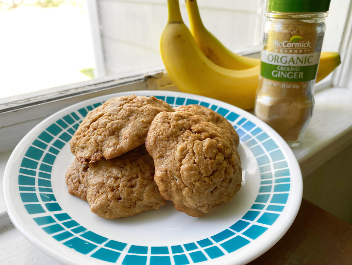 Ginger banana cookies on plate with bananas and ground ginger in background