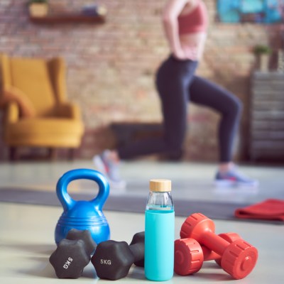 Girl working out at home with weights and water bottle