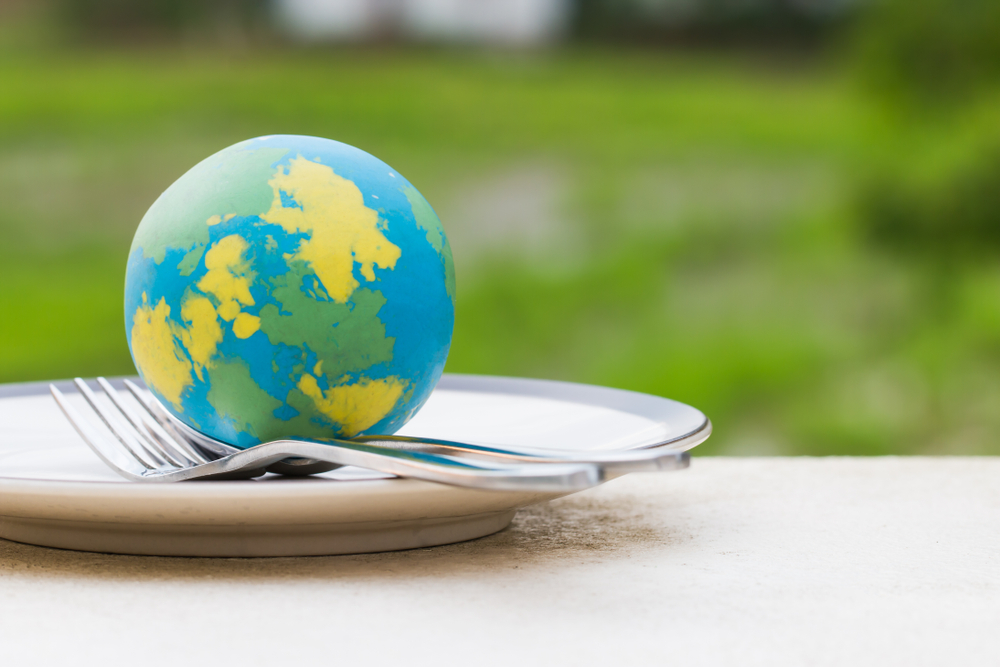 Globe model placed on plate with fork spoon for serve menu in famous hotels. International cuisine is practiced around the world often associated with specific region country. World food inter concept
