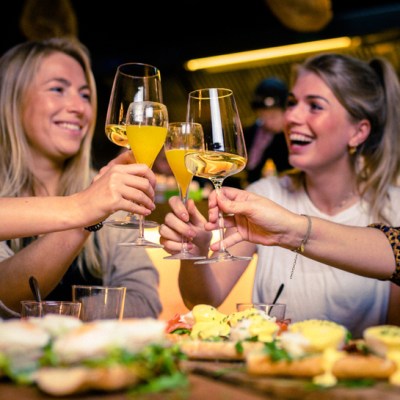 group of women drinking mimosas and wine at brunch