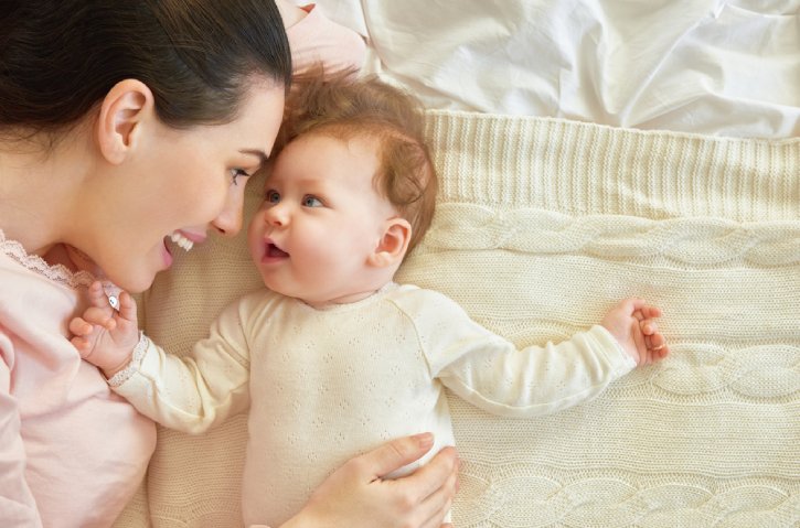 happy family. mother playing with her baby in the bedroom