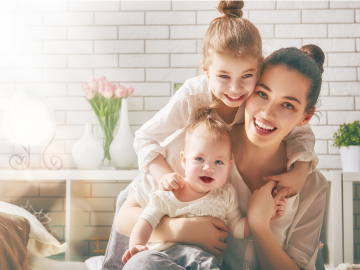 Happy loving family. Mother and her daughters children girls playing and hugging