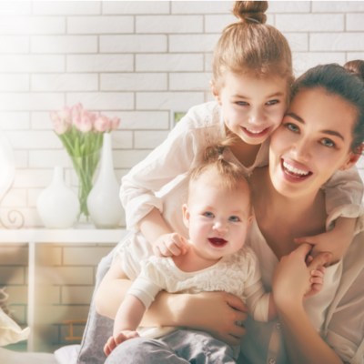 Happy loving family. Mother and her daughters children girls playing and hugging