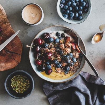 healthy vegan breakfast yogurt bowl with cherries, blueberries, and honey