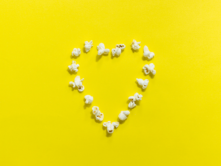 Heart made out of popcorn on yellow background