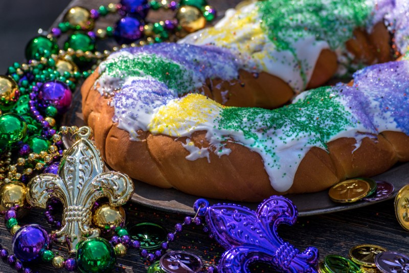king cake surrounded by mardi gras decorations