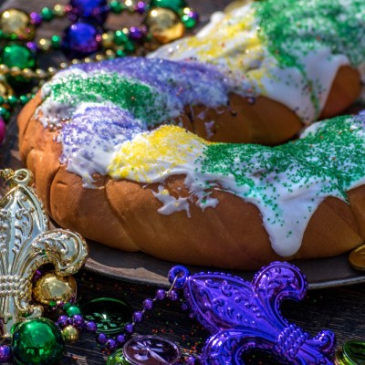 king cake surrounded by mardi gras decorations