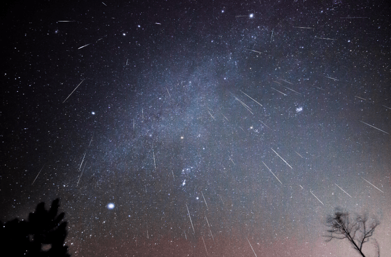 Long exposure shot of meteor shower in starry night sky