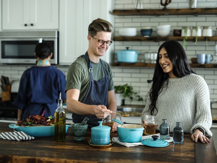 man and woman cooking together in kitchen