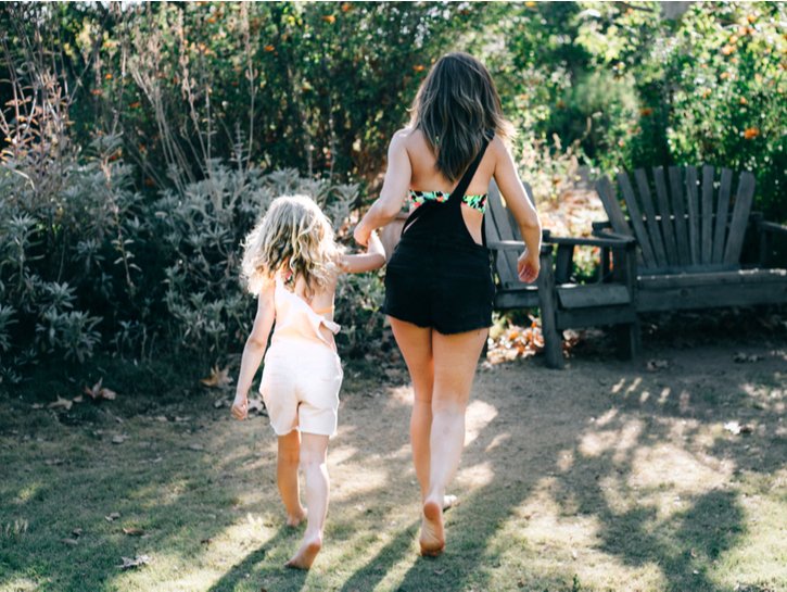 Mother and daughter enjoying summer in overalls and swimsuits