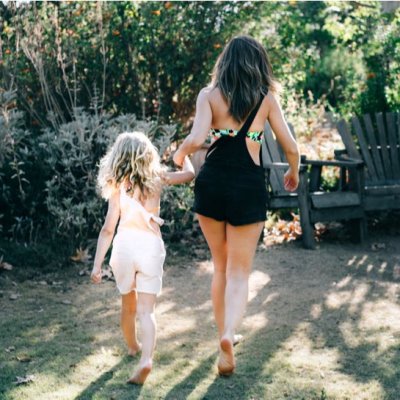 Mother and daughter enjoying summer in overalls and swimsuits