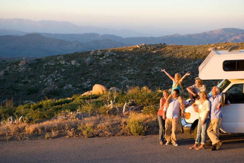 Multi-generation family relaxing in countryside on motor home vacation