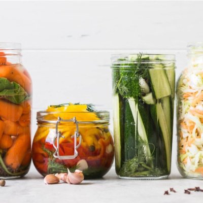 Pickled vegetables. Salting various vegetables in glass jars for long-term storage. Preserves vegetables in glass jars. Variety fermented green vegetables on table