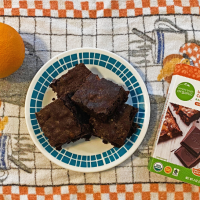 Plate of brownies on towel with baker's chocolate and orange