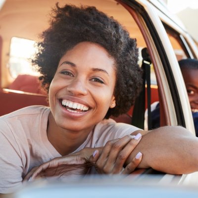 Portrait Of Mother And Children Relaxing In Car During Road Trip