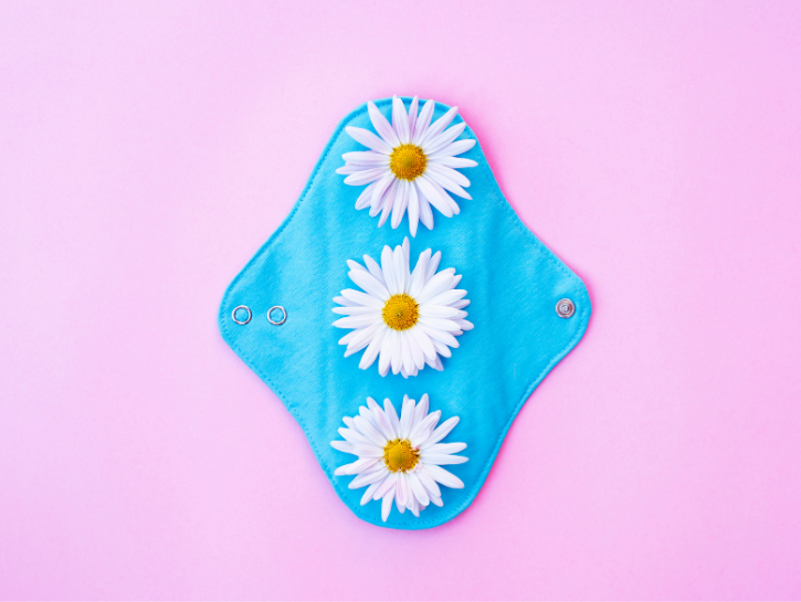 Reusable cotton pad with flowers on pink background