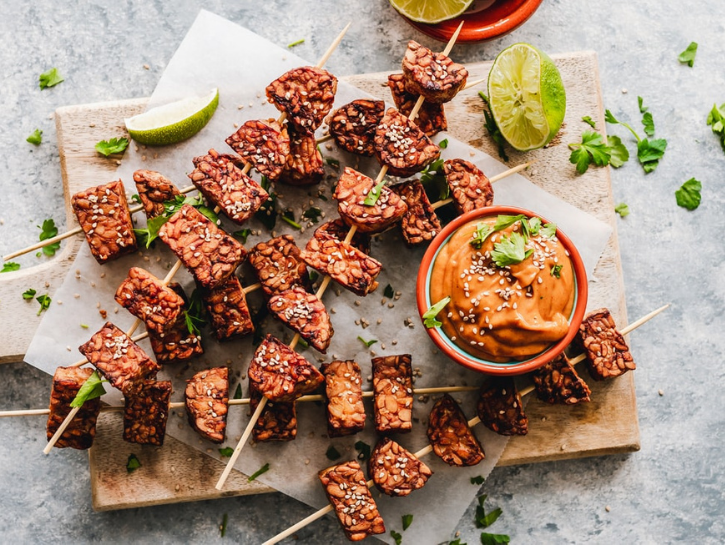 Sesame tempeh on skewers with orange dipping sauce