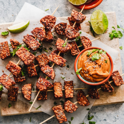 Sesame tempeh on skewers with orange dipping sauce