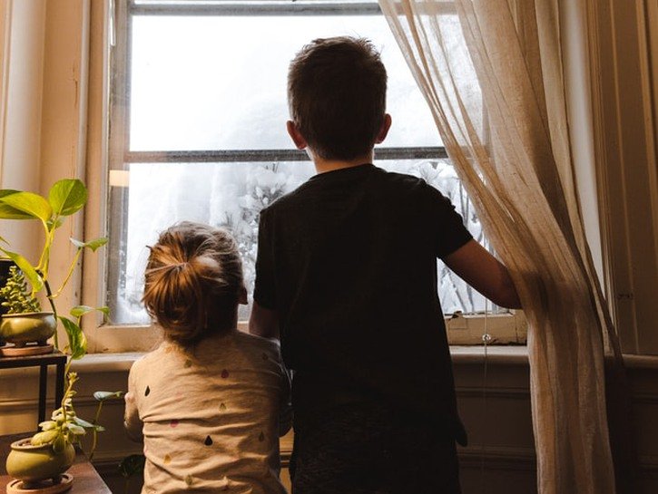 two children staring out window