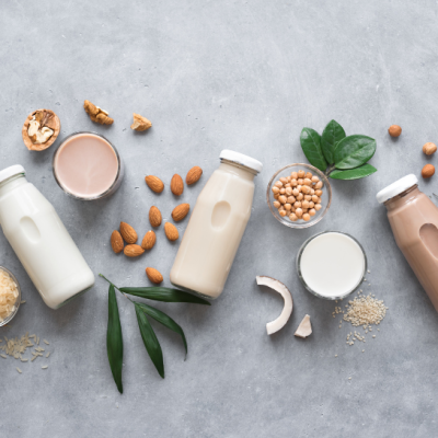 Variety of bottled plant-based milks next to ingredients