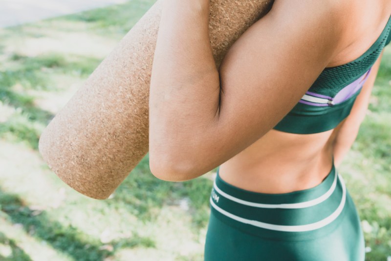 Woman going to yoga practice with cork mat