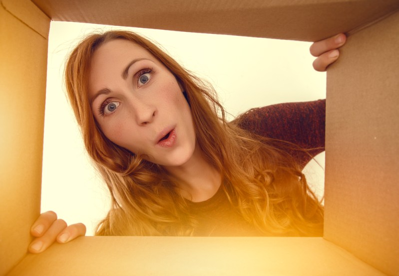 woman looking surprised into a box
