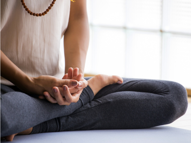 woman meditating with crossed legs indoors
