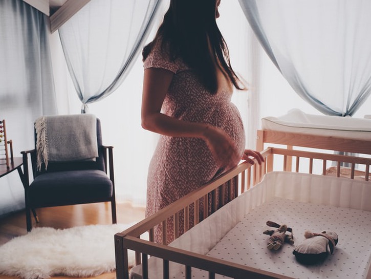 woman pregnant standing crib